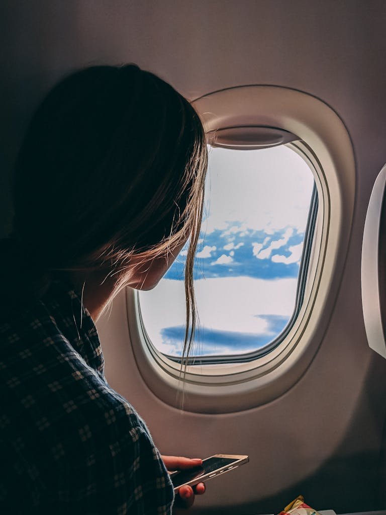 Person Holding Smartphone Airplane jetlag sarah long haul flight essentials